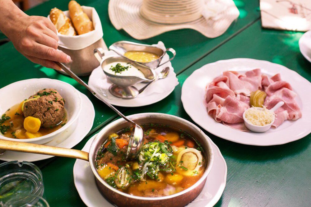 Traditional Austrian dishes served during a Vienna food tour, including soup, ham, and bread