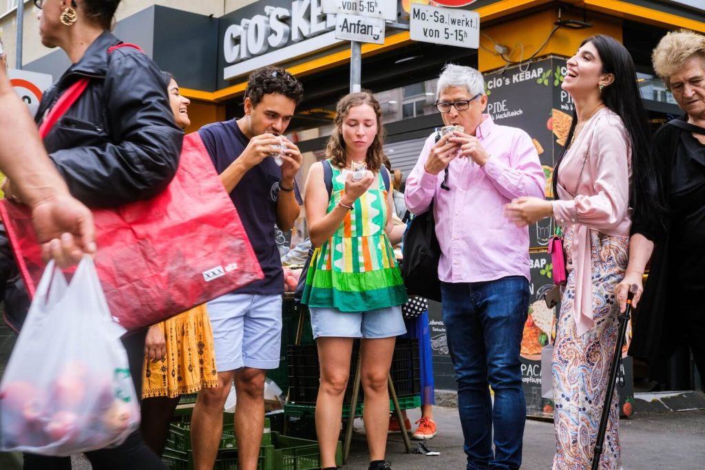 Guests tasting street food with a local guide during a Vienna food tour