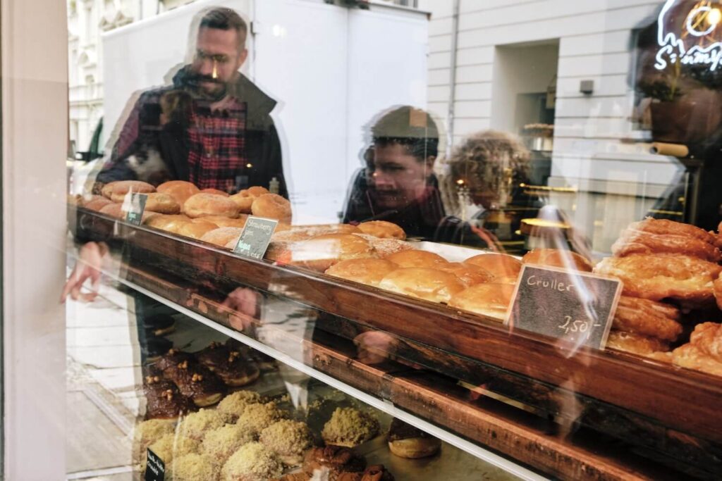 Guide and guests looking at pastries and bread in a Berlin bakery during a private food tour.