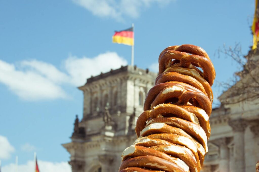 Fresh German pretzels with the Reichstag in the background, representing classic Berlin food culture.