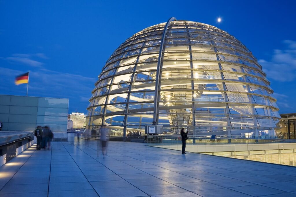 Illuminated Reichstag glass dome in the evening, a modern landmark of Berlin’s government quarter.