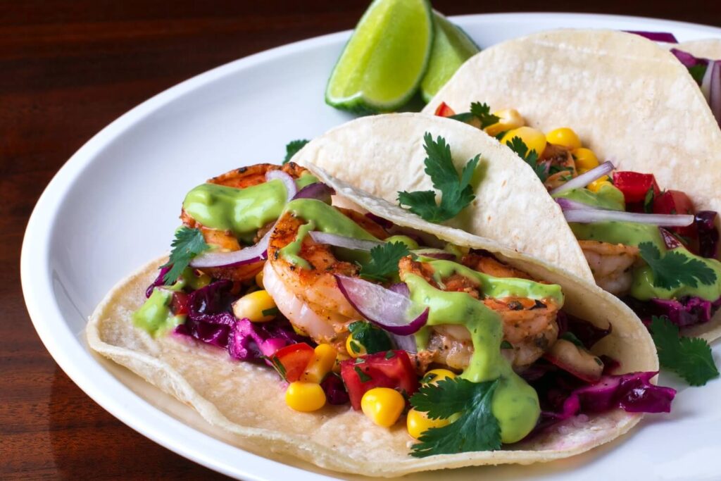 Shrimp tacos with lime, corn, cilantro, and avocado sauce, showing the international flavours of Berlin’s food scene.