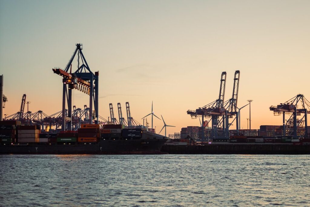 Harbor cranes and container port at sunset in Hamburg