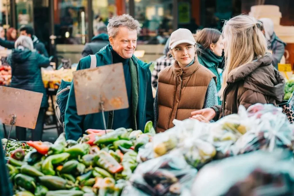Local guide speaking with guests at a Vienna food market