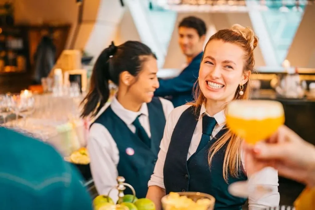 Bartenders smiling at guests during an evening nightlife tour in Vienna