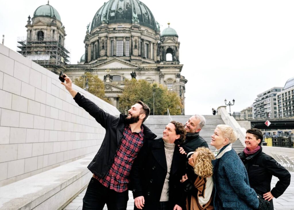 Private tour guests taking a group selfie in front of Berlin Cathedral.
